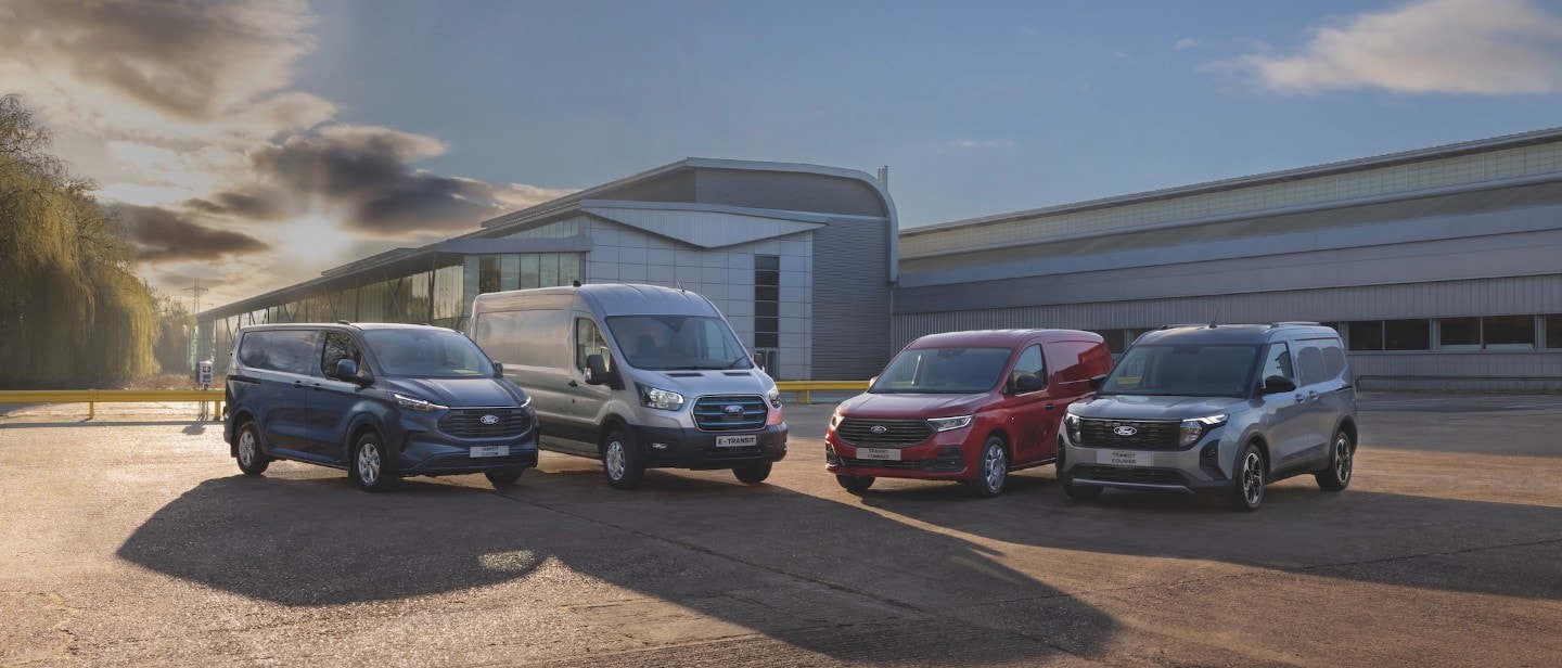 A range of four commercial vehicles outside a warehouse lot, including a Ranger Plug-in Hybrid pick-up and Transit vans.
