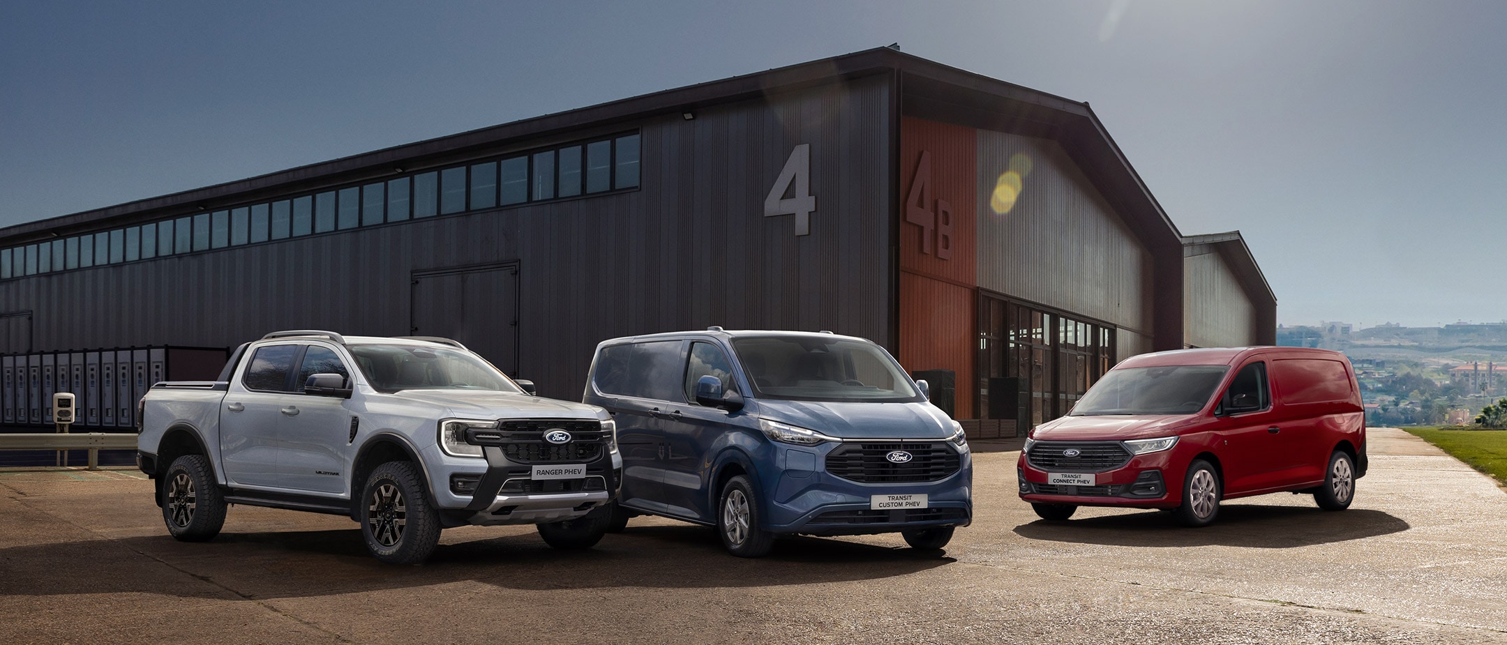 Ford Ranger PHEV, Transit Custom PHEV, and Transit Connect PHEV parked in front of building 4.