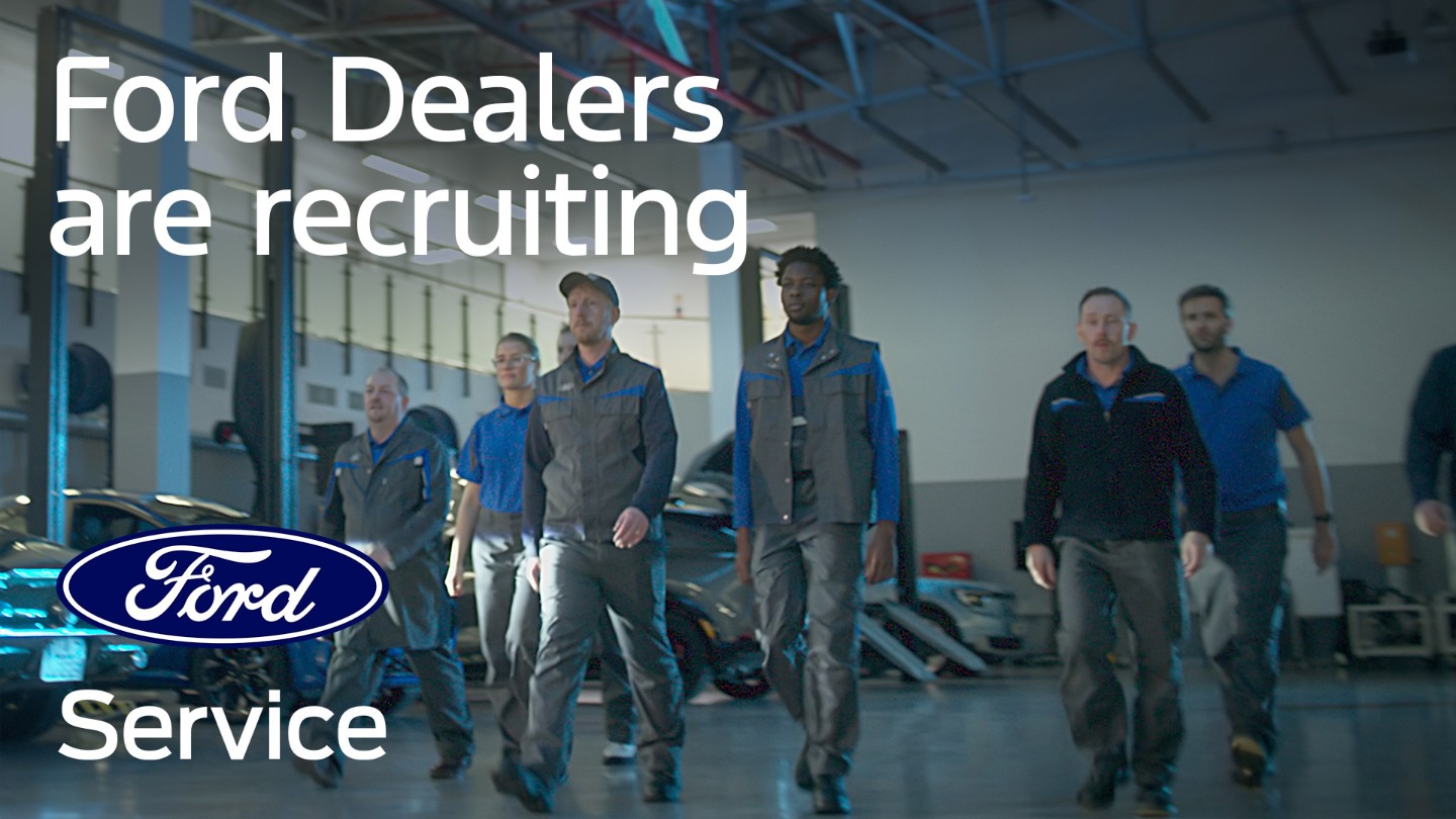Ford technicians walk towards the camera in a dealership garage. The text "Ford Dealers are recruiting" and the Ford service logo are displayed.