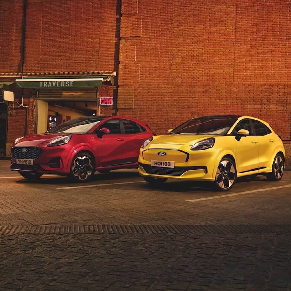 A red Ford Puma and a yellow Ford Puma parked side-by-side in an urban setting.