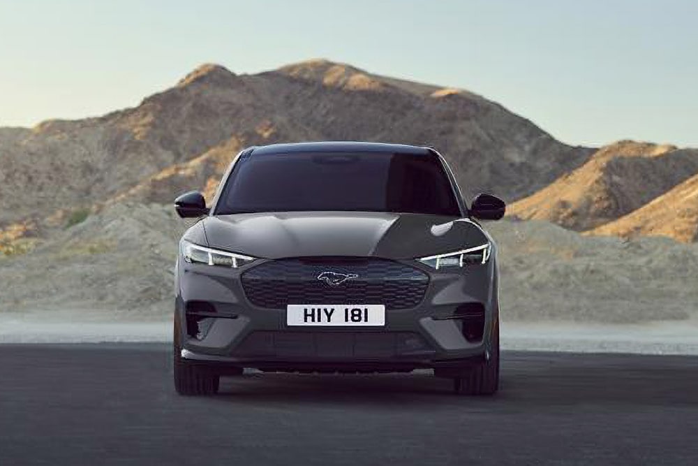 Grey Ford Mach-E, front view, with mountains in the background.