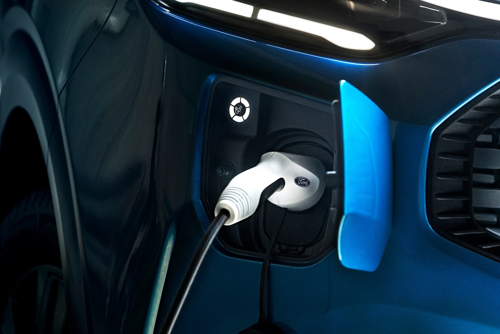 A close up of an electric charging cable plugged into a Ford E-Transit Custom electric van.