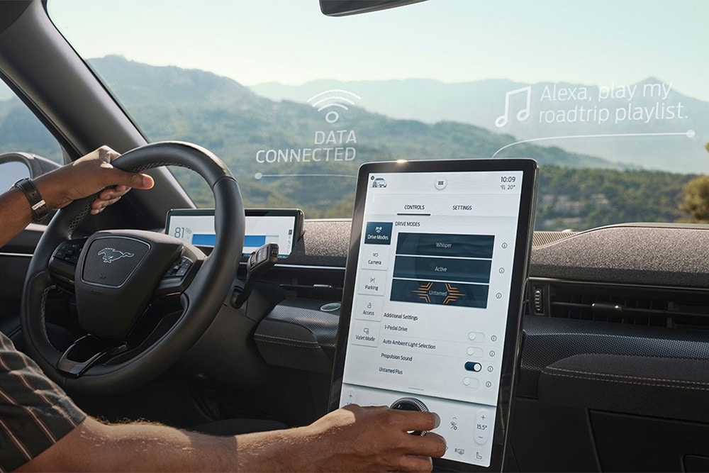 A close up on the driver of a Ford Mustang Mach-E interacting with the large 15.5" SYNC 4 touchscreen