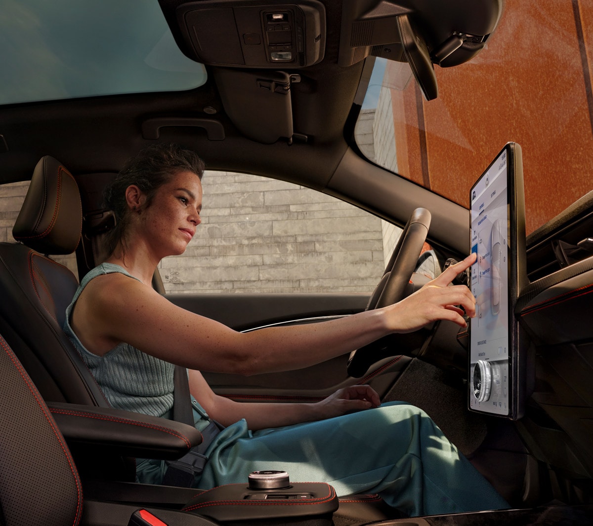 Ford Mustang Mach-E interior view of woman using SYNC 4