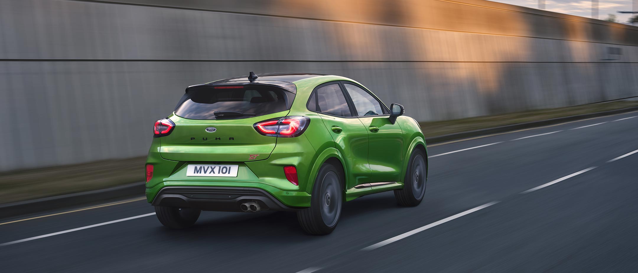 Green Ford Puma ST rear view driving on road