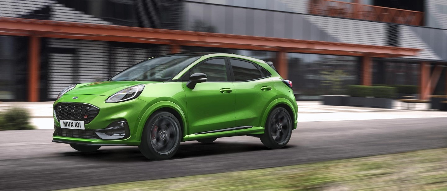 Green Ford Puma ST driving on road side view