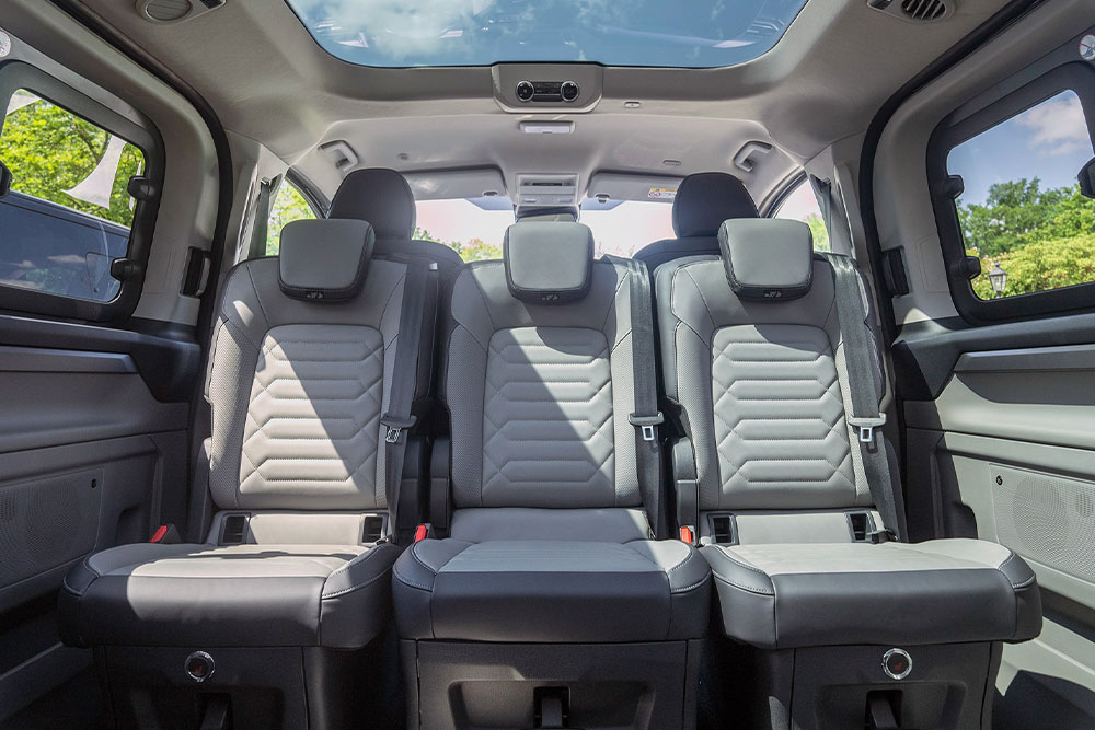 Interior view of a vehicle, showing the gray back seats and a sunroof.