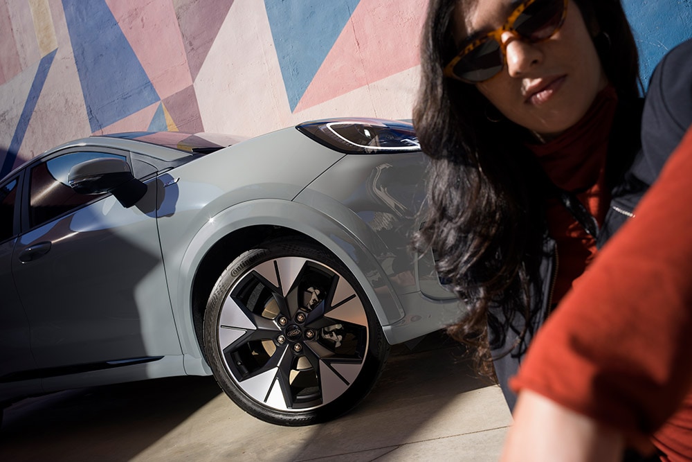 A close-up of a person next to a grey Ford Puma® with a petrol EcoBoost® engine.