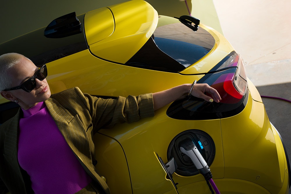 A close-up on the rear of the electric Ford Puma Gen-E®, plugged into a home wallbox.