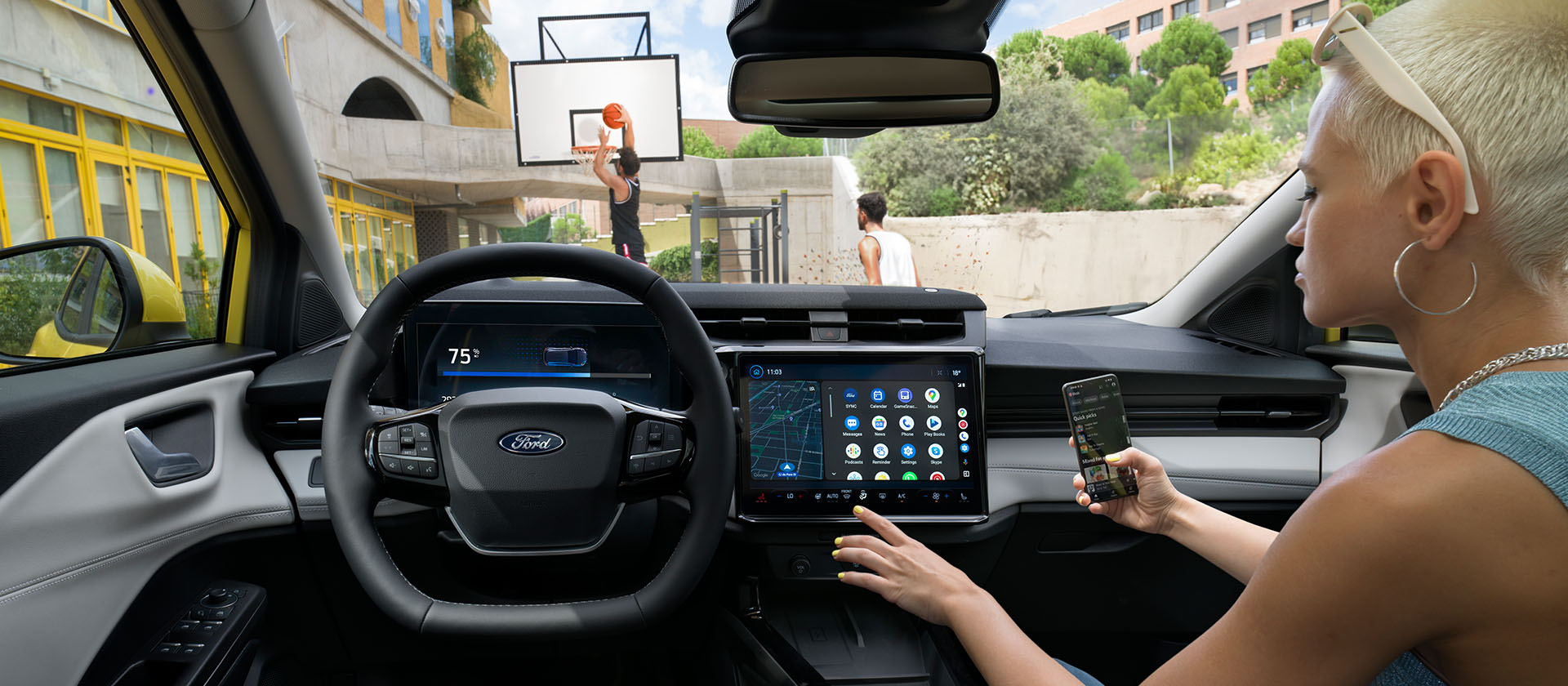 The interior of the electric Ford Puma Gen-E®, with a person wirelessly syncing their mobile phone to the large touchscreen.