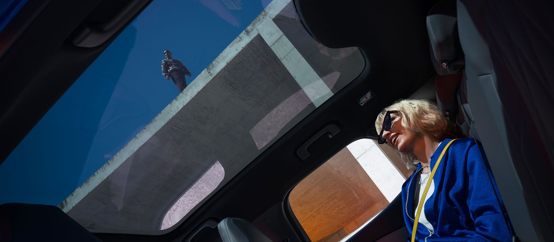 Person sitting inside the new Ford Capri® enjoying the panoramic glass roof.