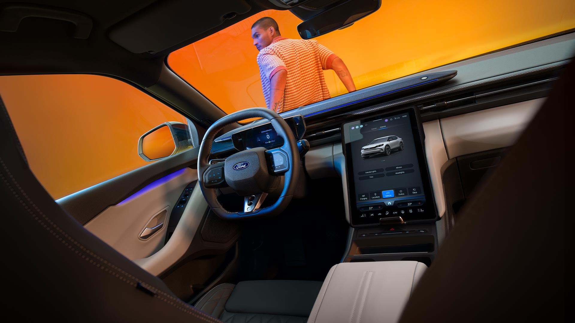 The interior of the Ford Capri while parked in a yellow photography studio. A man leans on the front of the car.