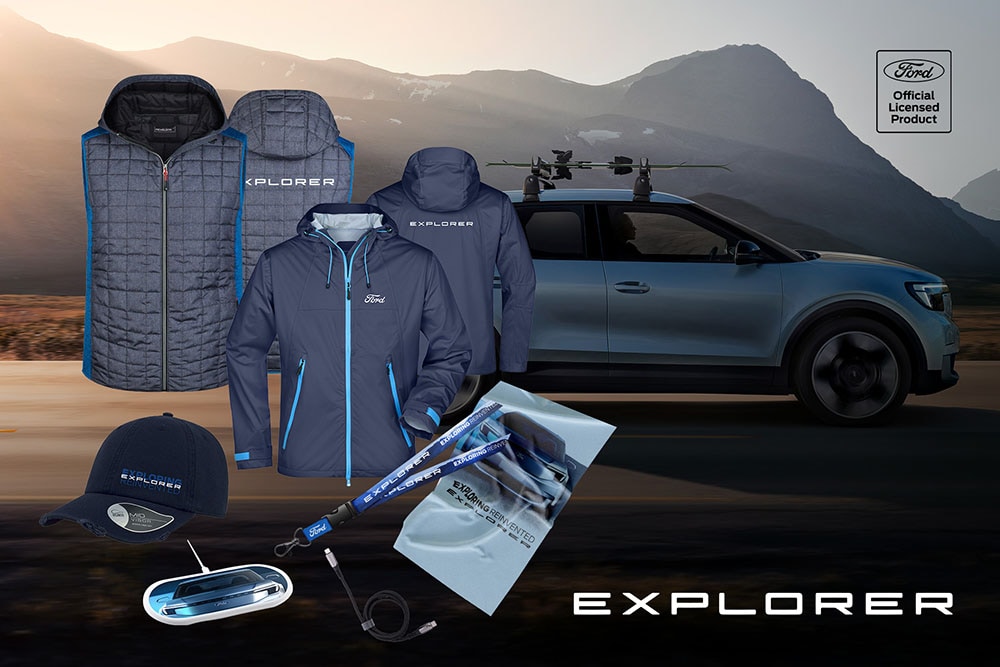 Blue Ford Explorer merchandise including jackets, cap, and other accessories, displayed in front of a blue Ford Explorer.