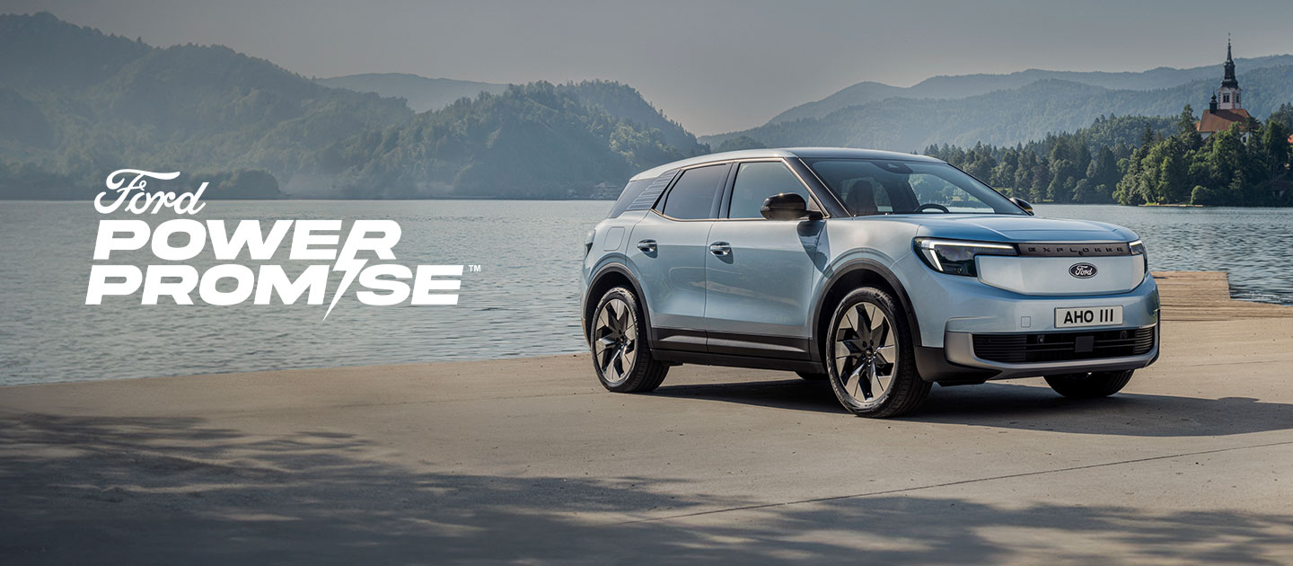 The New All-Electric Ford Explorer® in Arctic Blue paint, parked by a lake.