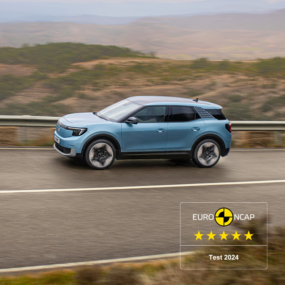 A blue Ford Explorer driving along a mountain road, with the 2024 five-star Euro NCAP logo on the top left corner.