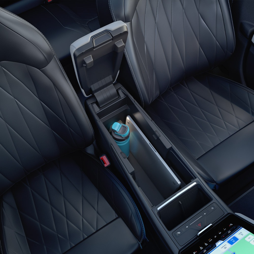 A close-up of a laptop and water bottle inside the MegaConsole in the centre console of the Ford Explorer.