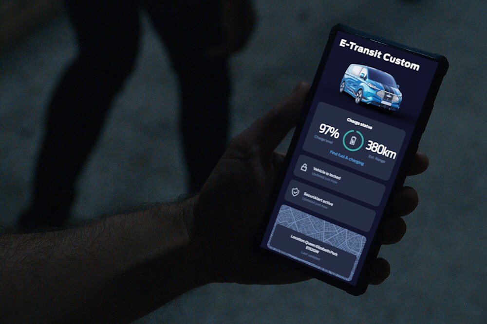 Smartphone displaying an E-Transit Custom in the FordPass app, showing vehicle charge status and location.
