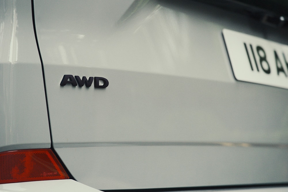 The rear of a silver Ford Tourneo Custom, showing the "AWD" badge.