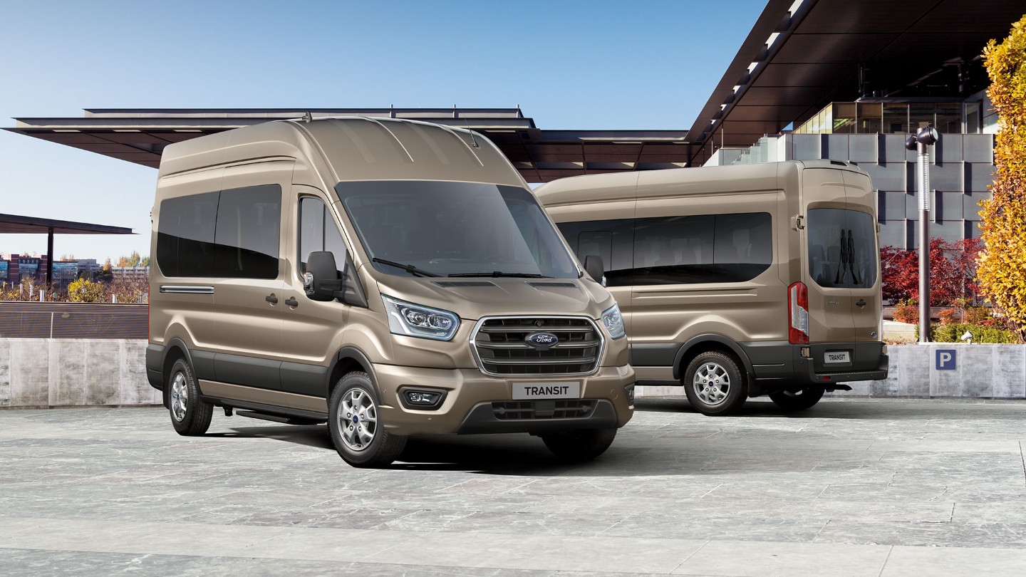 Two New gold Ford Transit Minibuses parked side by side