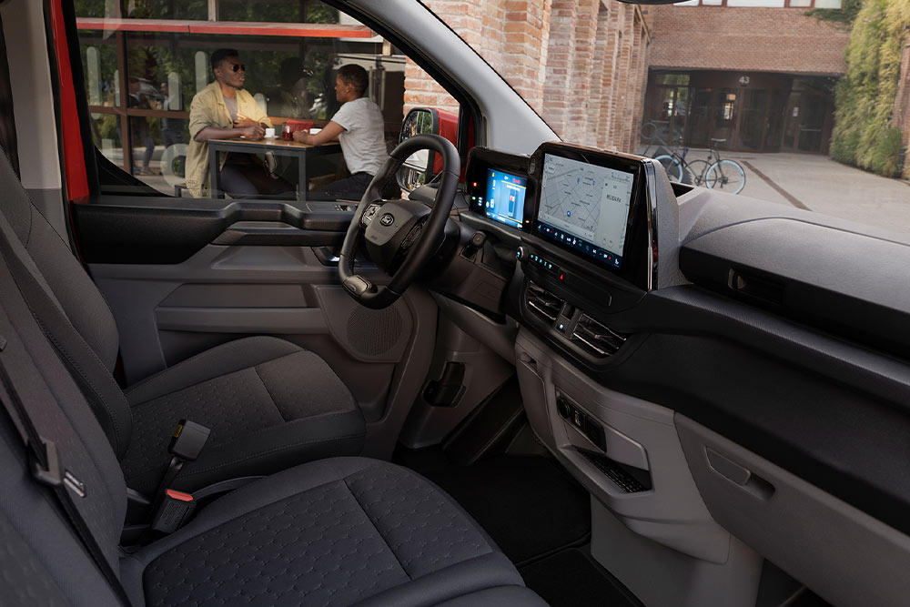 Interior of Ford Transit Custom with steering wheel, digital instrument cluster, dashboard and infotainment touchscreen.