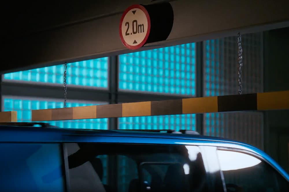 Blue Ford E-Transit Custom electric van entering a parking garage.