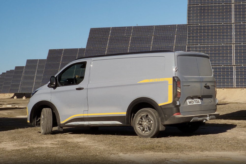 Grey Ford Transit Custom Trail van with yellow accents.