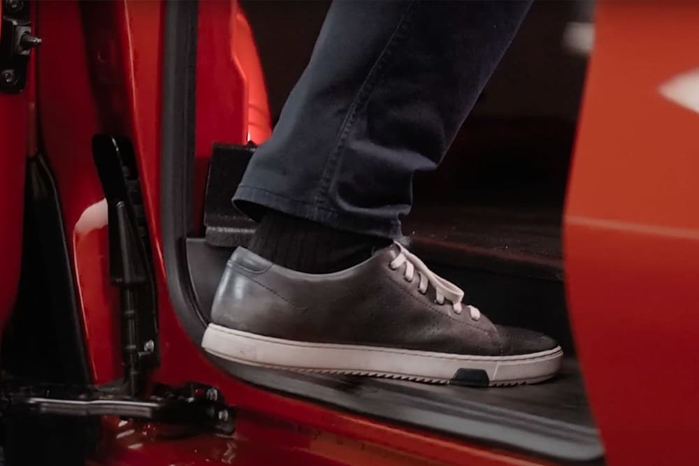 Foot stepping into a Ford Transit Custom van.