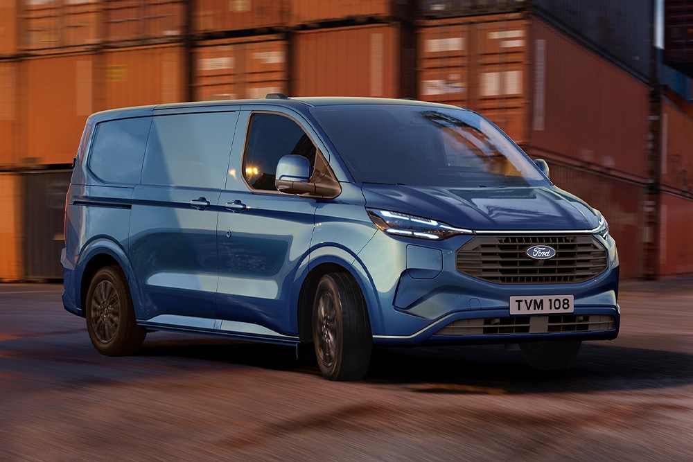 Blue Ford Transit Custom Plug-in Hybrid van drives through a dockyard.