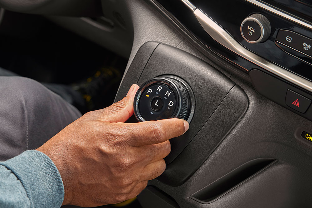 Close-up of a hand turning the gear selector knob in a Ford E-Transit electric van.