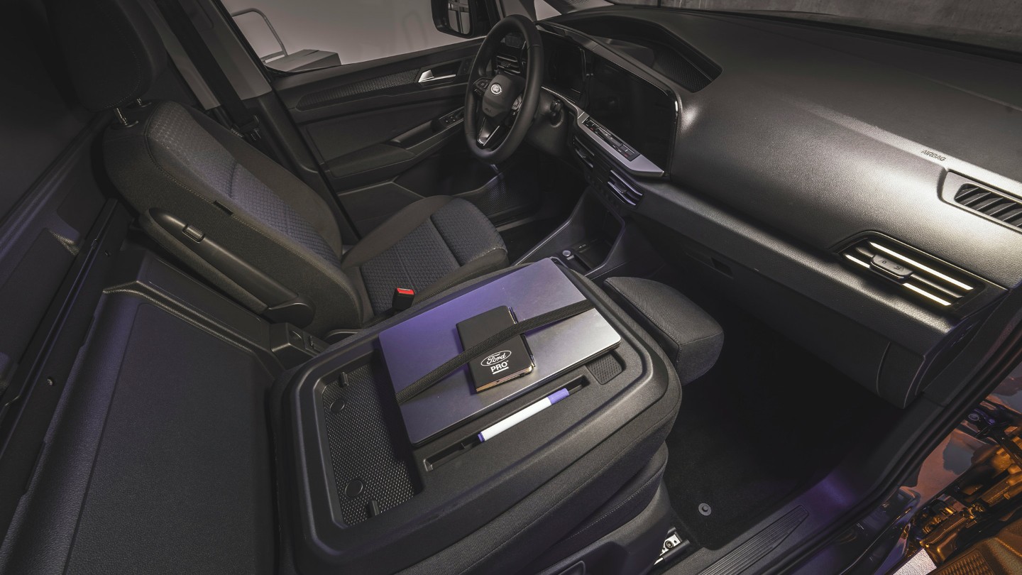 A laptop and Ford Pro notebook lie on the work surface table of All-New Ford Transit Connect.