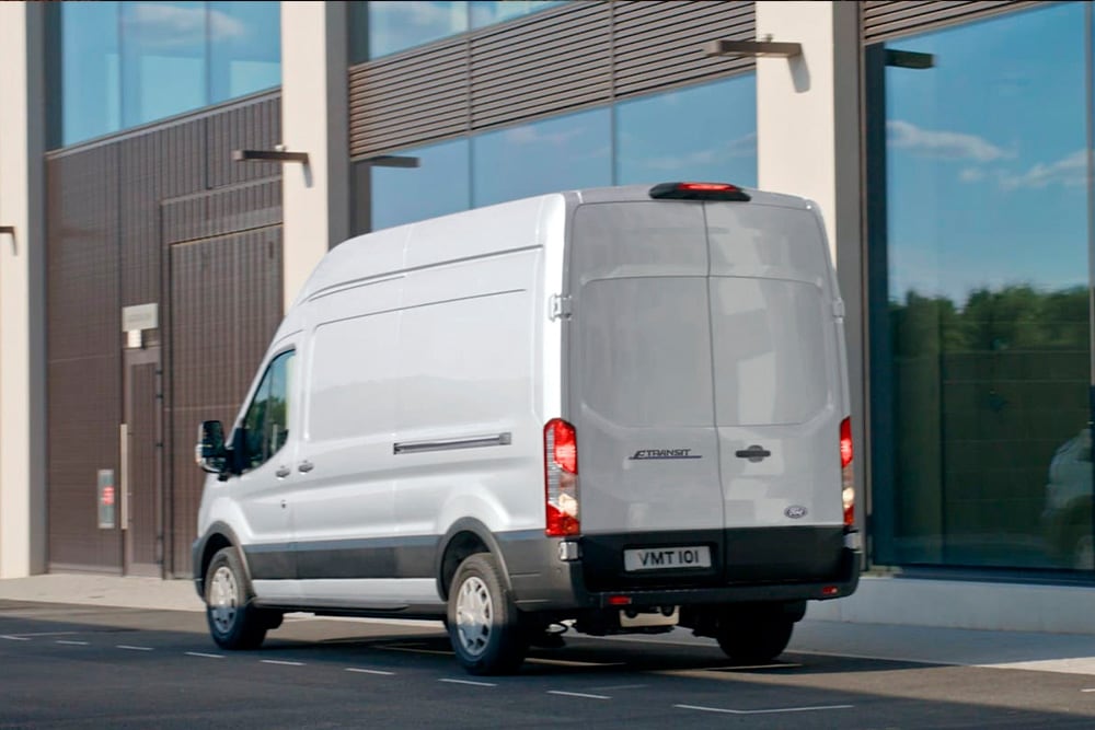Rear of a silver Ford Transit Van parked on a city street.