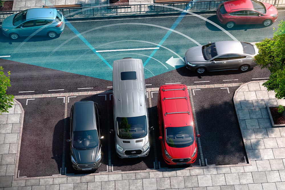 Silver Ford Transit Van reversing, with blue lines depicting use of rear parking sensore. 