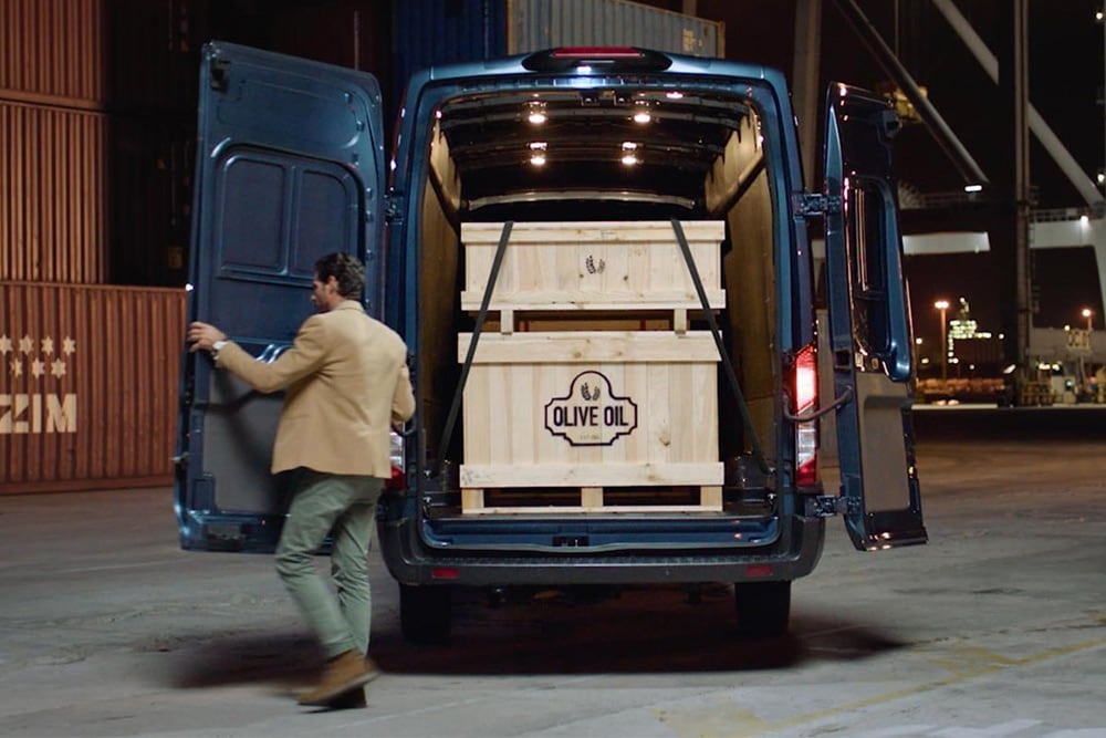 Ford Transit Van with open rear doors, cargo inside.