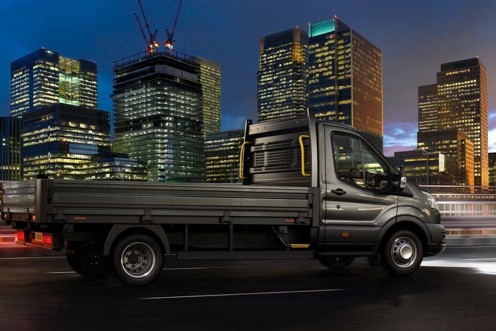 Ford Transit Chassis Cab driving along a city road at night. 