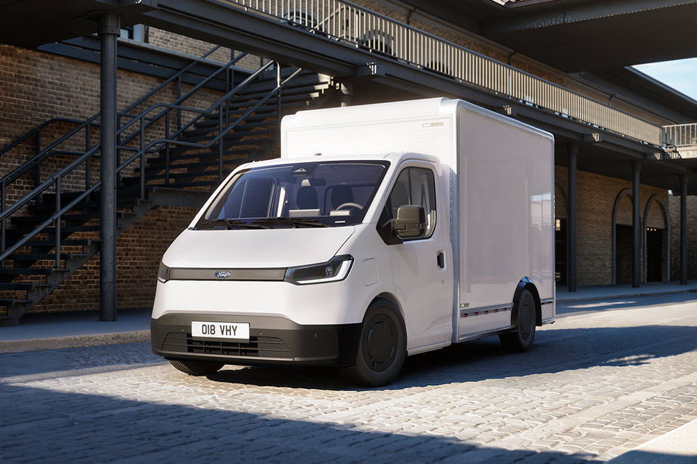 White All-New Ford Transit City® Chassis Cab van parked in front of a brick building.