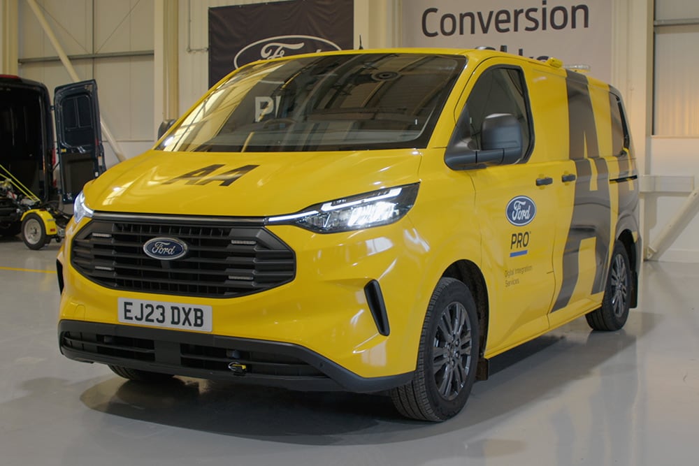 Yellow Ford van parked in a garage.