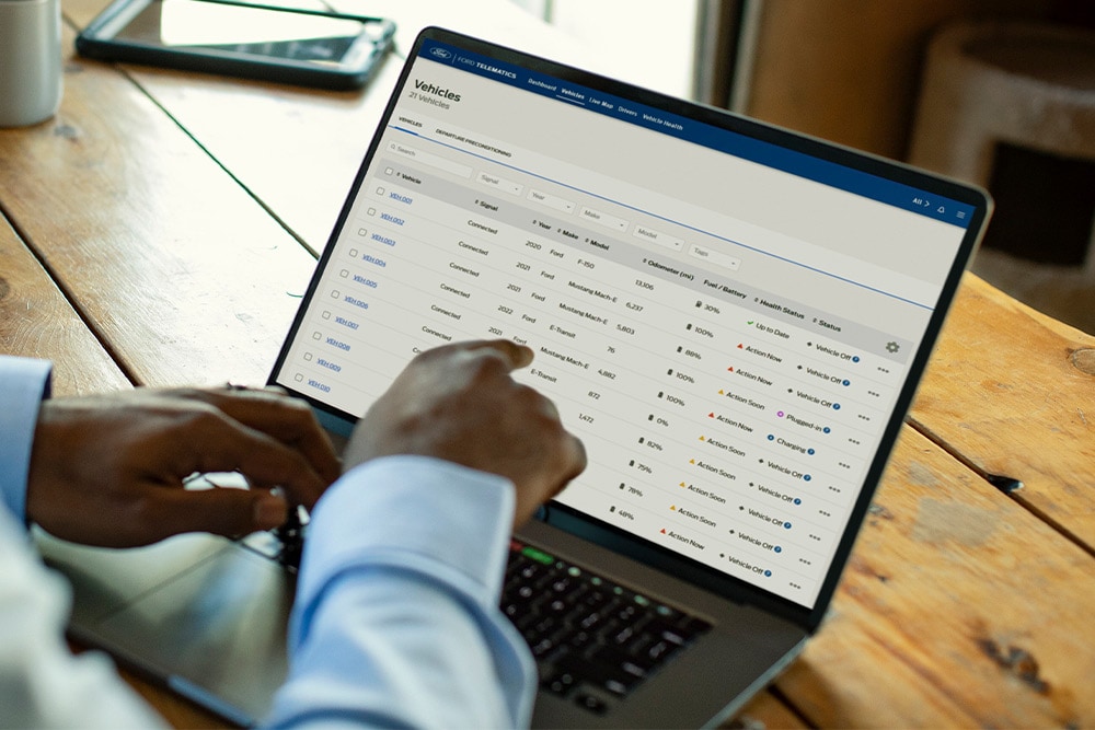 Ford Pro Fleet manager viewing vehicle data on his laptop.