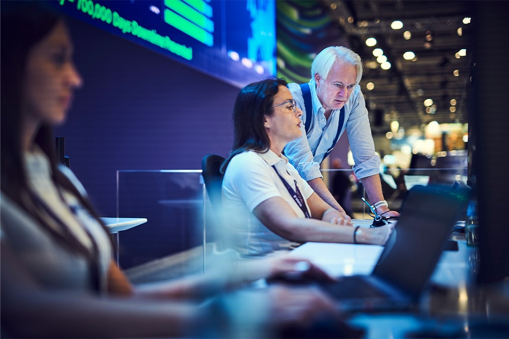 A group of three people in a Ford Liive Centre, focusing on screens with data displays.