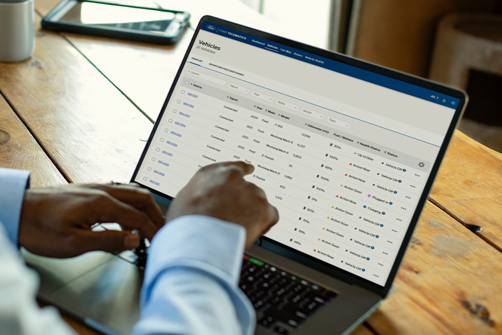 Ford Pro Fleet manager viewing vehicle data on his laptop.