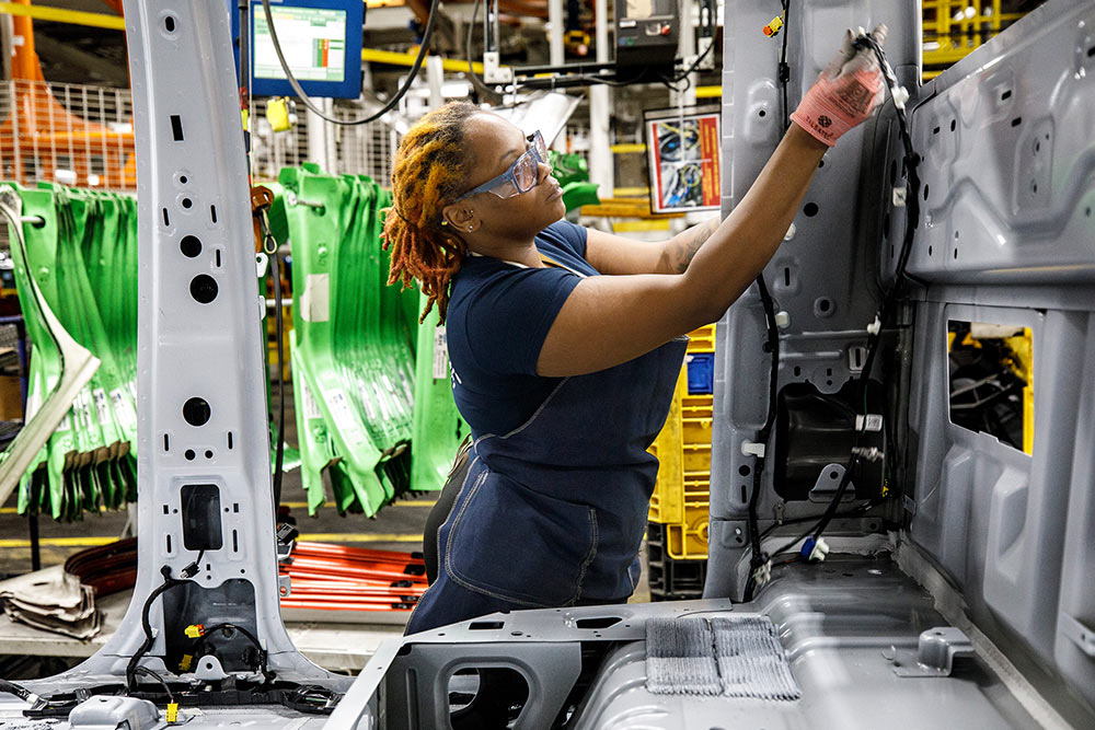 Ford mechanic working on a van in a garage.