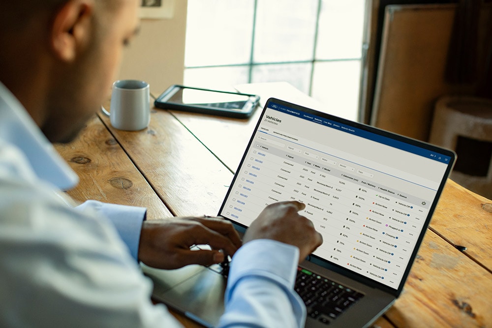 Ford Pro Fleet manager viewing vehicle data on his laptop.