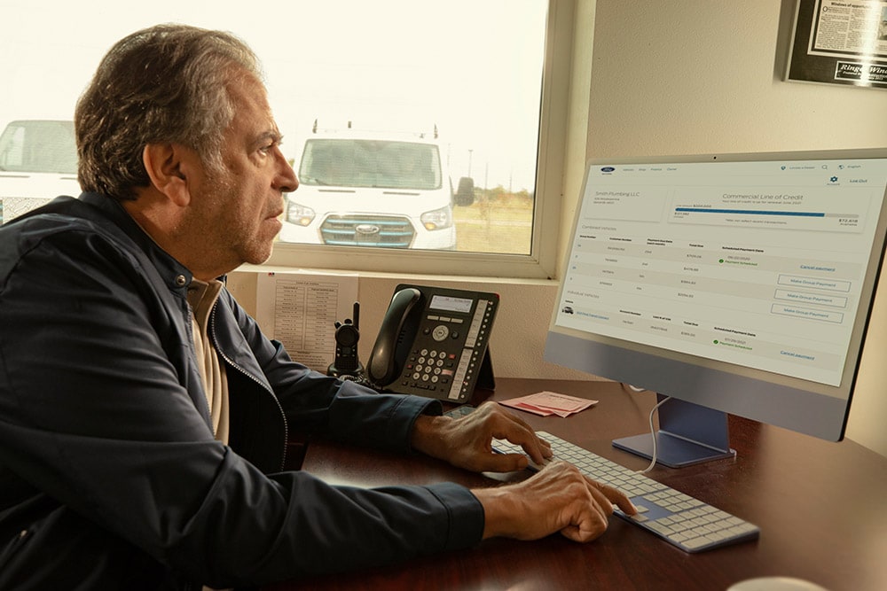 Man reviewing his Ford fleet data on a desktop computer.