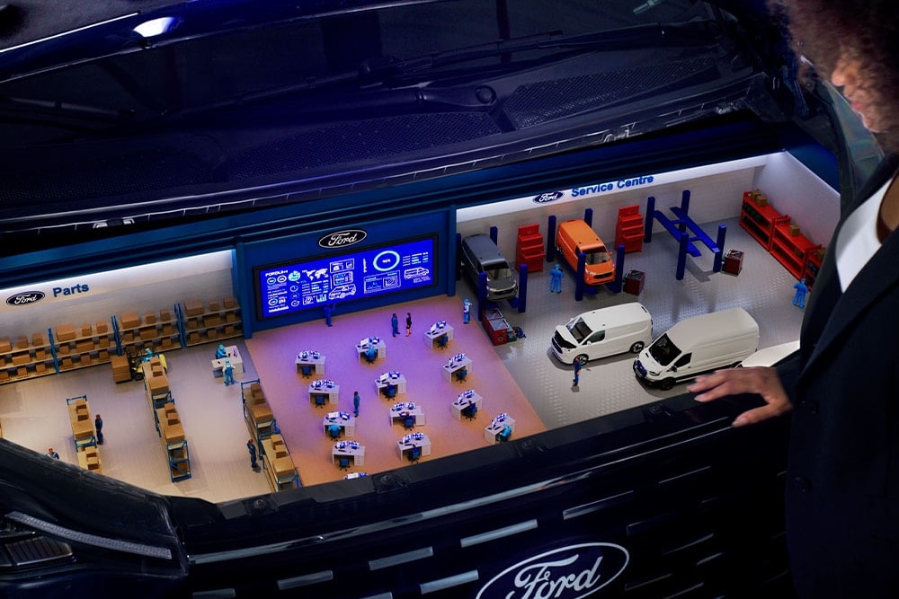 Miniature model of a Ford service centre inside a car trunk.