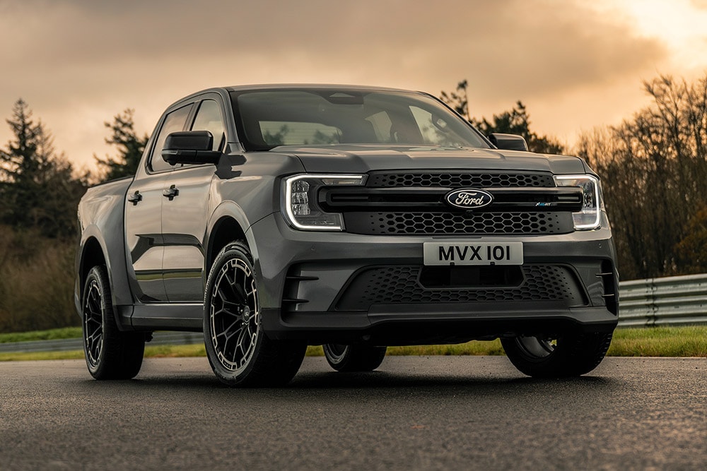 Grey Ford Pro Ranger Plug-in Hybrid parked on a wet road, trees in the background.