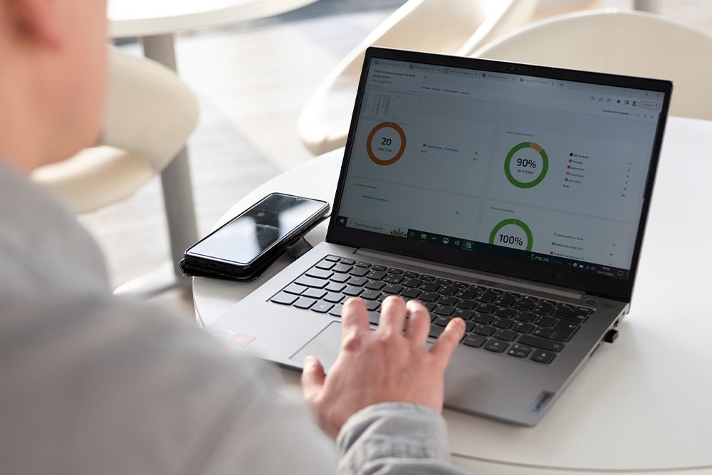 Person on a laptop reviewing a Ford Pro Telematics dashboard with various fleet performance metrics.